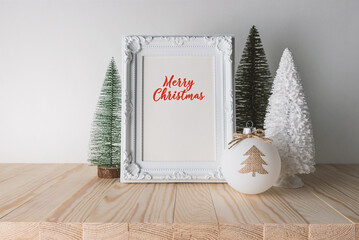 Wall Mural - Holiday concept with Christmas decor and photoframe on wooden table. Creative Christmas or New Year background.