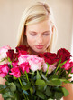 © Cameron M/peopleimages.com - Woman, rose bouquet and eyes closed with face, beauty and arrangement with studio background, happy or gift. Smell, female model or flowers for love, present and valentines day with romantic gesture