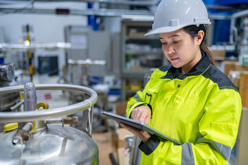 Asian engineer working at Operating hall,Thailand people wear helmet  work,He worked with diligence and patience,she checked the valve regulator at the hydrogen tank.