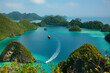 © RooM The Agency - Speedboat sailing past a tourboat in a tropical lagoon, Wayag, Raja Ampat, West Papua, Indonesia