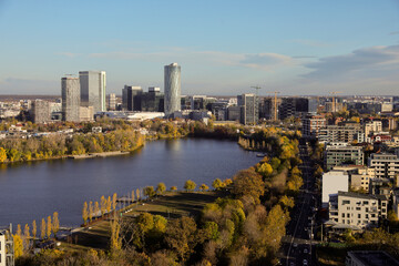 Bucharest from above, aerial view over Herastrau (King Michael I) Park, lake and the north part of the city with office building photographed during a autumn day after sunrise.