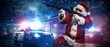 © Fxquadro - A man dressed as Santa Claus, holding a machine gun, poses in front of police cars with numerous police lights and sirens, amid a snowy stormy night on the street