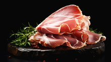 Sliced Prosciutto ham close-up. Prosciutto slices with Rosemary on a dark wooden board on dark background. Sliced Jamon delicacy with fresh herbs on dark Backdrop. Traditional italian appetizer