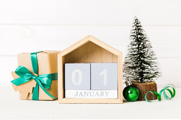 Wall Mural - 1 january. Christmas composition on colored background with a wooden calendar, with a gift box, toys, bauble copy space