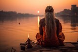 Fototapeta  - religious hindu elderly man sitting on a rock in the river meditating and praying