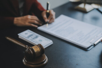 Justice and law concept.Male judge in a courtroom with the gavel, working with, computer and docking keyboard, eyeglasses, on table in morning light