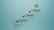 © G-Studio - Sequential progress and milestone accomplishment concept, wooden steps with checkmarks symbolizing task completion, ascending towards goal achievement in a structured approach on teal background