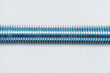 © Yashkin Ilya - iron threaded stud on a white background. metal rod with thread on a light background. construction long bolt with thread for fastening