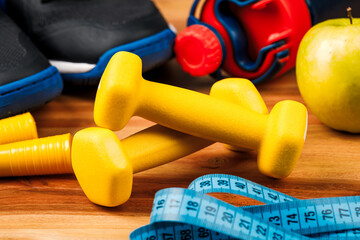 Sports equipment on a wooden table, weight loss and physical activity concept.