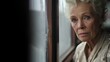 © Natalia - An older woman looking out a window. Generative AI.