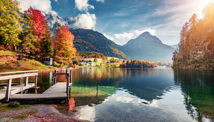 Wall Mural - wonderful autumn landscape popular alpine lake grundlsee with colorful trees scenic image of forest landscape at sunny day stunning nature background majestic mountains on colorful scenery