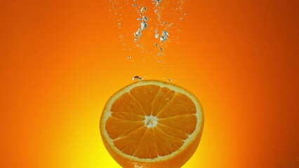 Fototapete - Super slow motion of falling fresh orange into water on orange gradient background. Filmed on high speed cinema camera, 1000 fps.