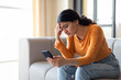 © Prostock-studio - Bad News. Upset Indian Woman Reading Message On Smartphone At Home