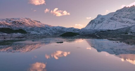 Wall Mural - aerial view from low flying drone of sea coast, snowy mountains in winter at sunrise. lofoten island