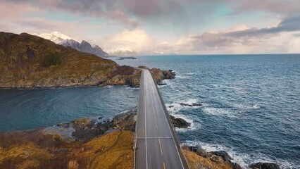 Wall Mural - aerial view of bridge, sea with waves and snowy mountains at sunrise in winter. lofoten islands, nor