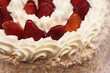 detalhe de torta com cobertura de morango e nata na vitrine da confeitaria