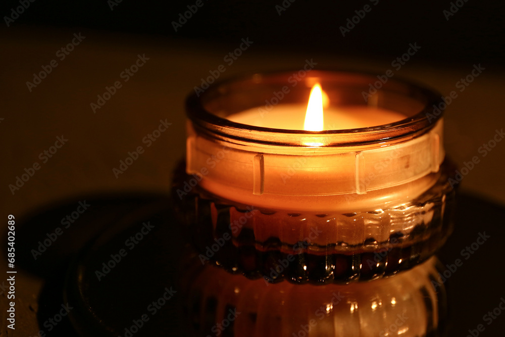 Beautiful burning candle on black background