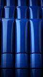 Fototapeta Kuchnia - A collection of skincare tubes in a deep sapphire blue, neatly organized in a row. Blank labels for customization. Copy space on blank label.