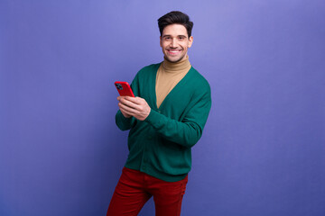 Canvas Print - Photo of attractive successful man wear green stylish clothes use modern device iphone samsung isolated on purple color background