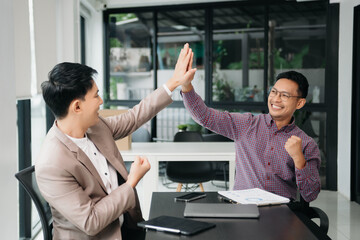 Wall Mural - Businessman leading team meeting and using tablet and laptop computer with financial in co working office