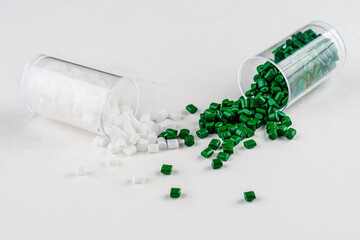 Wall Mural - white and green plastic dye in granules in test tubes isolated on a white background