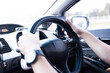 Close-up of a man's hand holding the steering wheel inside a car while driving