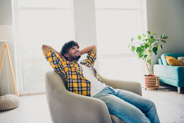 Canvas Print - Photo of handsome attractive man chief sitting in comfy armchair apartment holding hands behind head enjoying break