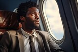 Fototapeta  - Black businessman gazing out of airplane window