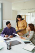 © DragonImages - Indian businesswoman discussing results of marketing campaign with colleagues in meeting