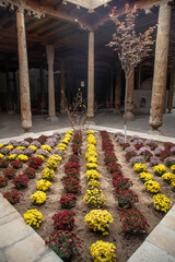 Center of historical place with the tree and lot of colorful flowers, Khiva, the Khoresm agricultural oasis, Citadel.