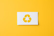Hand holding card with recycle symbol on yellow background generated AI