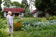 © Westend61 - Senior man watering plants with hose pipe in garden