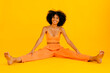 © Westend61 - Smiling woman spreading legs against yellow background