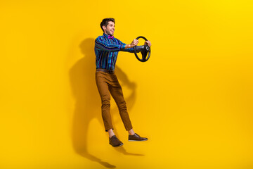 Poster - Full size photo of funny positive guy dressed striped shirt hold steering wheel look empty space isolated on yellow color background