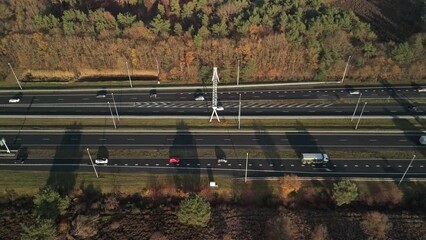 Wall Mural - Highway with traffic runs through nature with autumn forest, Aerial