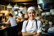 Junge Küchenchefin steht stolz vor Ihrer Küche im Restaurant. Führungskraft in der Gastronomie oder Jungköchin bei der Arbeit. Auszubilden Köchin in der Restaurantküche.