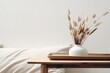 Modern white ceramic vase with dry Lagurus ovatus grass and marble tray on vintage wooden bench, table. Blurred beige linen blanket in front. Scandinavian interior. Empty white wall. generative ai.