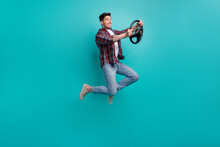 Full Length Photo Of Cheerful Funky Guy Wear Checkered Shirt Jumping High Driving Car Isolated Teal Color Background
