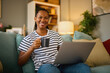 © Stockphotodirectors - Happy african american woman with laptop at home