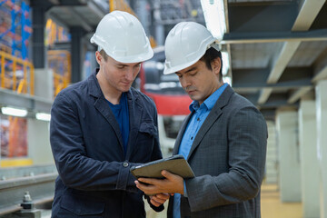 Bosses and business owners inspect the condition of electric trains at the tracks in the maintenance shop.