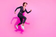 Full length photo of good mood charming girl dressed glamour overall running jumping high empty space isolated pink color background