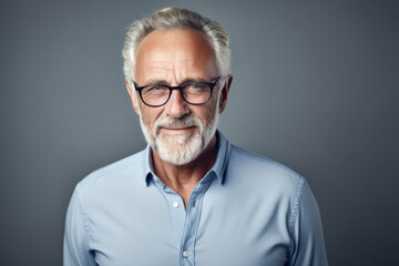 Portrait of a handsome senior man with grey hair and glasses.