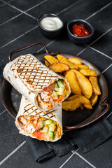 Wall Mural - Shawarma Shaurma kebab with meat, vegetable salad and french fries. Black background. Top view