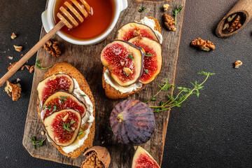 Wall Mural - Bruschettas with figs and cheese on a dark background. top view. copy space for text