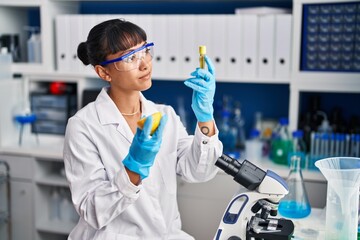 Sticker - Young beautiful hispanic woman scientist holding lemon and test tube at laboratory