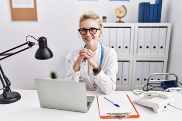 Canvas Print - Young blonde woman doctor using laptop working at clinic