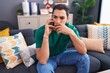 © Krakenimages.com - Young hispanic man talking on smartphone with worried expression at home