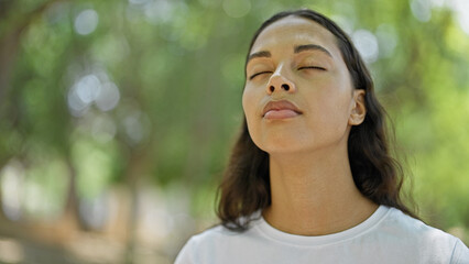 Wall Mural - African american woman breathing with closed eyes at park