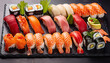 Assorted sushi nigiri and maki set on slate.