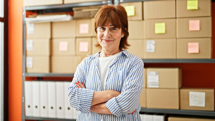 Poster - Middle age woman ecommerce business worker standing with arms crossed gesture at office